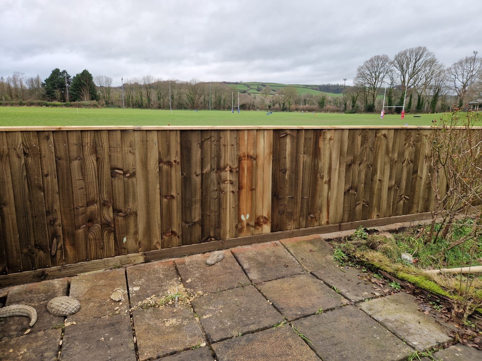 New close-board timber fence along a garden boundary next to a playing field