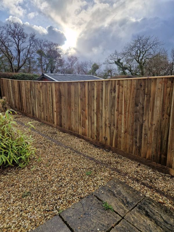 Close-board fence above a gravel border