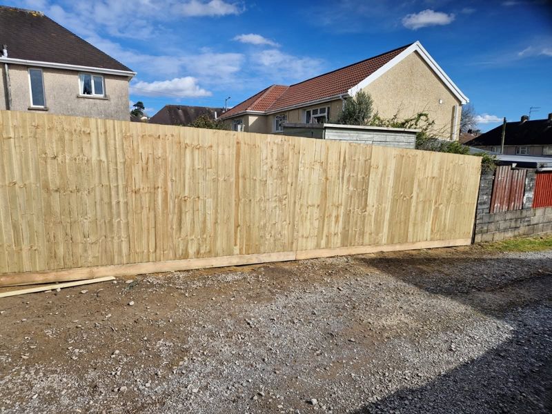Close-board fencing along a driveway