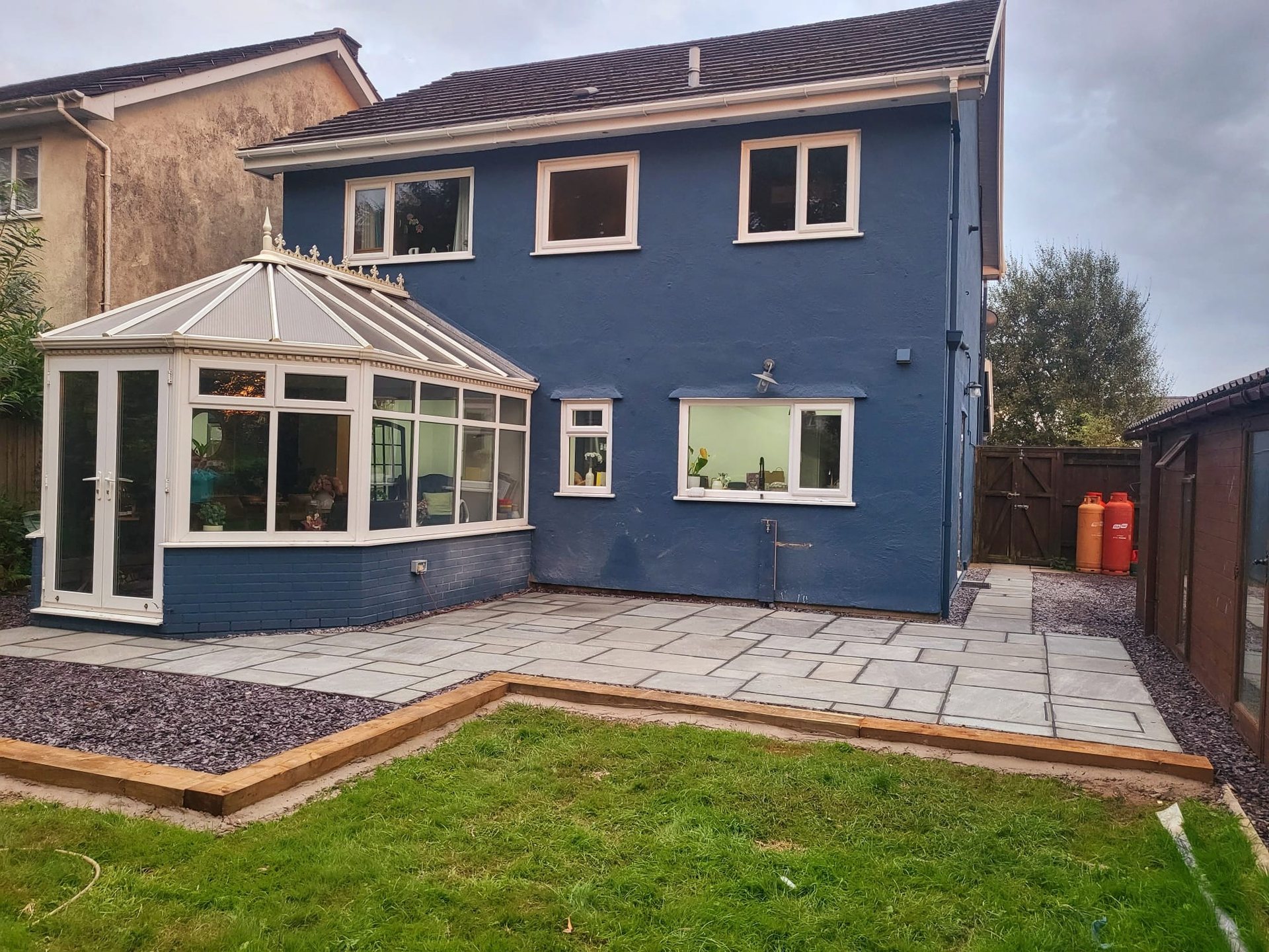 Back garden makeover with a new grey sandstone patio, sleeper edging, slate chippings and lawn