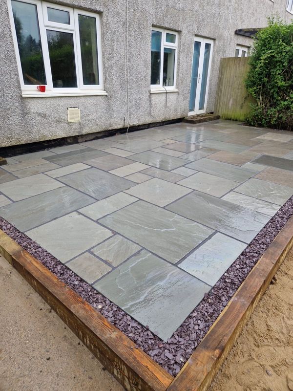 Sandstone patio framed with sleepers
