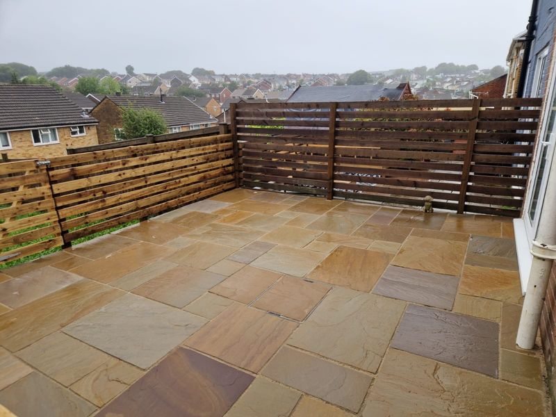 Indian sandstone patio with slatted fencing
