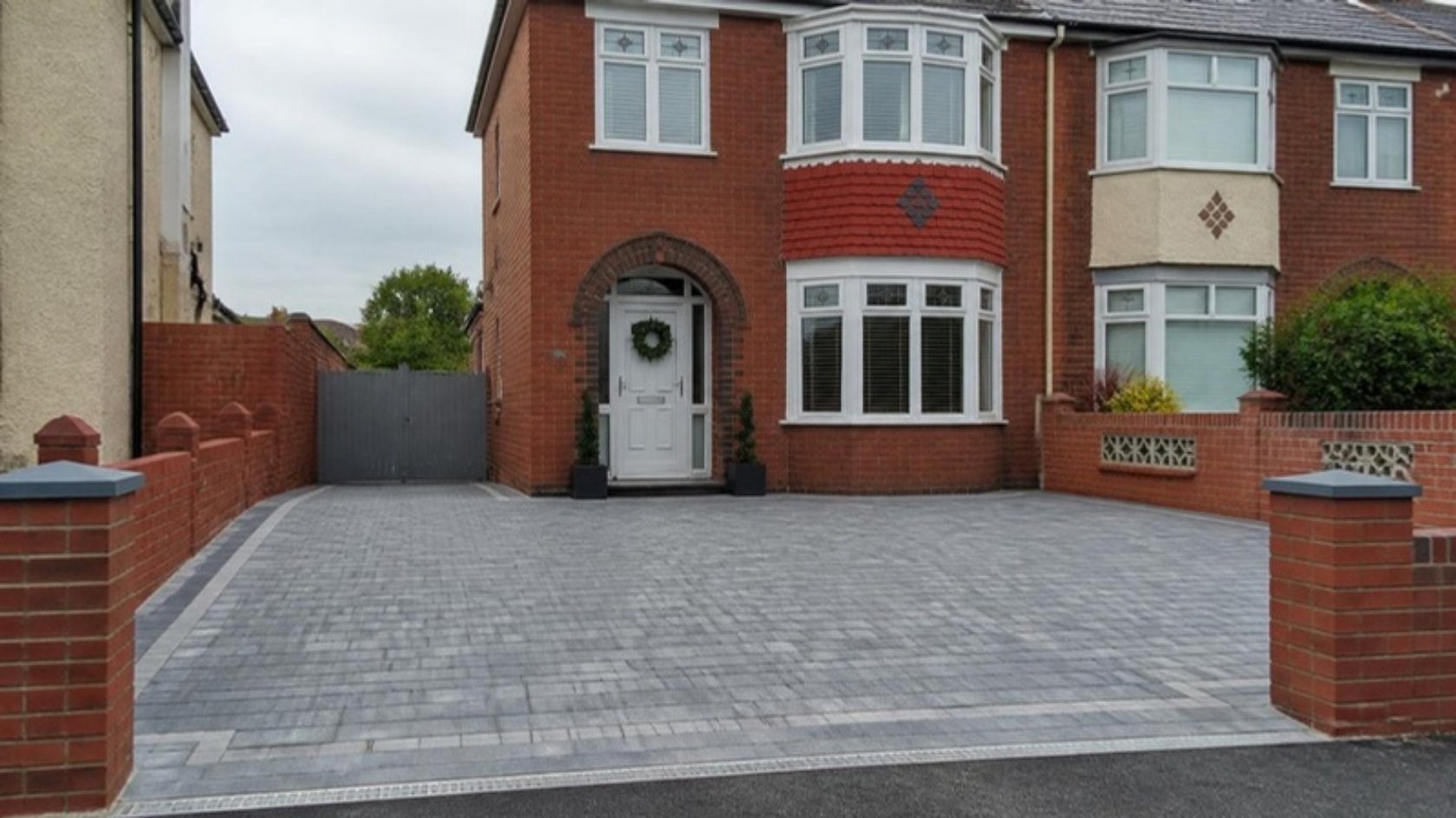 New block paved driveway in front of a red-brick semi-detached house